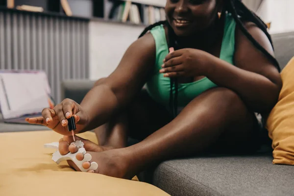 Close Joyful Size African Woman Painting Toenails While Sitting Couch — Stock Photo, Image