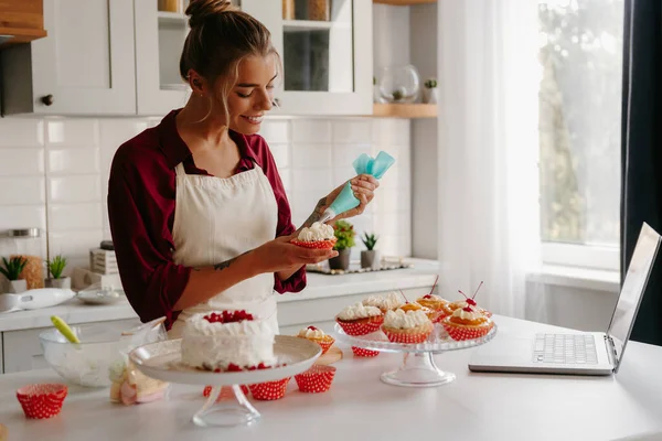Happy Female Baker Decorating Muffins Whipped Cream While Standing Domestic — Stock Photo, Image