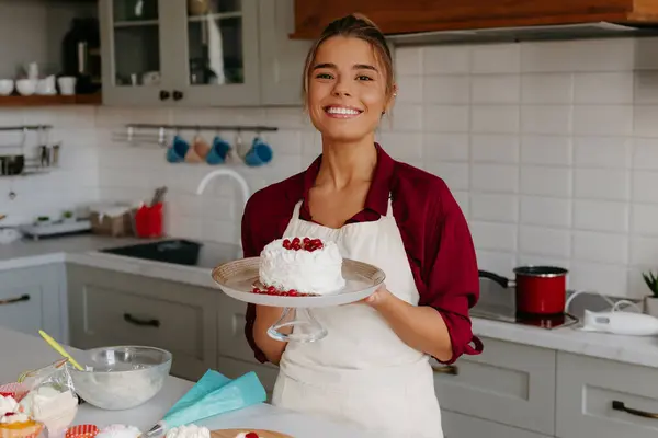 站在厨房时 自豪的女面包师拿着自制的蛋糕微笑着 — 图库照片