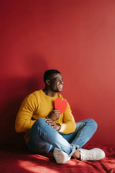 Щасливий Молодий Африканський Чоловік Тримає Картку Валентина Формі Серця Сидячи — стокове фото
