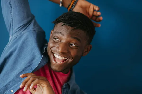 Грайливий Молодий Африканський Чоловік Повсякденному Одязі Посміхається Жестикулює Синьому Фоні — стокове фото