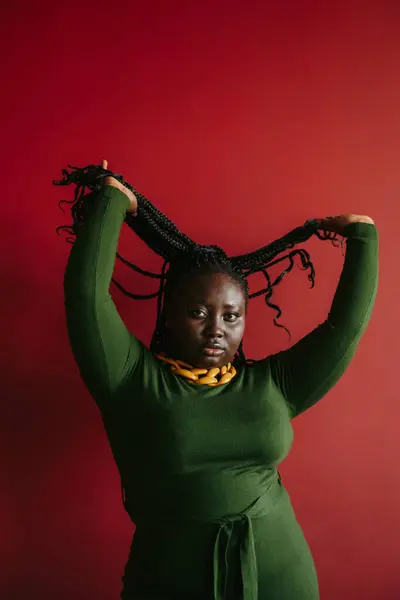 Krásné Velikost Africké Žena Úprava Její Spletené Vlasy Červeném Pozadí — Stock fotografie