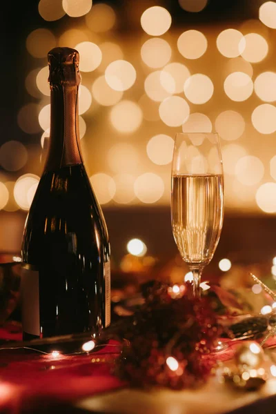 新年イブの居心地の良い雰囲気のシャンパンのボトルで装飾された休日のテーブルの夜撮影はありません — ストック写真