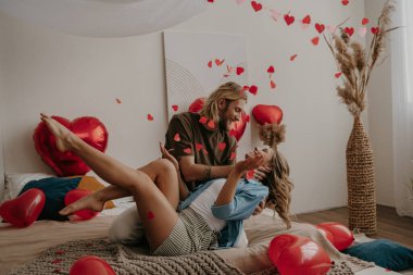 Sevgililer Günü 'nü evde kutlarken neşeli çiftler birbirlerine bağlanıp kalp şeklinde konfeti atıyorlar.