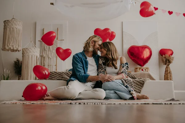 Belo Casal Amoroso Abraçando Inclinando Cama Casa Enquanto Balões Forma — Fotografia de Stock