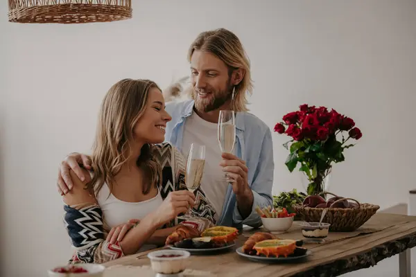 Romantik Genç Çift Evde Masada Yıldönümünü Kutlarken Şampanyayla Kadeh Kaldırıyor — Stok fotoğraf