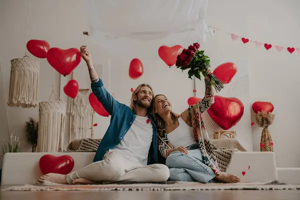 Glückliches Liebespaar Feiert Den Valentinstag Hause Zusammen Mit Roten Herzballons lizenzfreie Stockbilder