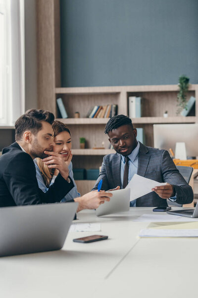 Three confident business people planning strategy while working in the office together