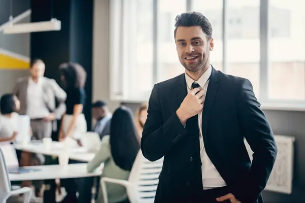 Усміхнений Молодий Бізнесмен Формальному Одязі Коректує Краватку Його Колеги Працюють — стокове фото