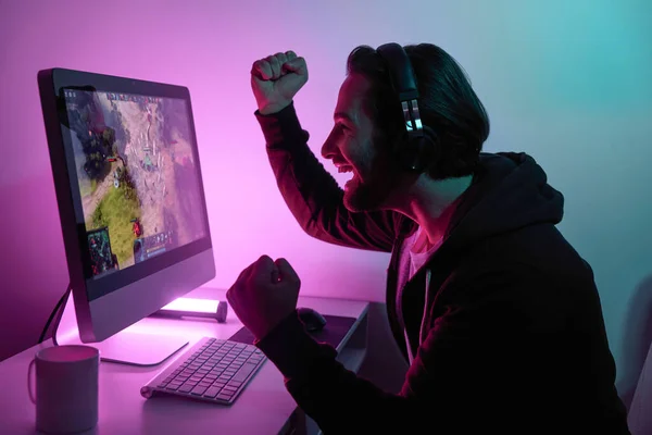 Seitenansicht Glücklicher Mann Gestikuliert Beim Computerspiel Vor Buntem Hintergrund lizenzfreie Stockfotos