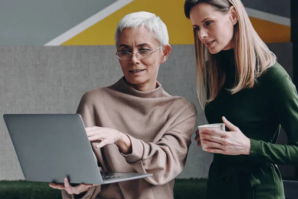 Duas Mulheres Confiantes Que Usam Tecnologias Comunicam Enquanto Trabalham Escritório Imagem De Stock