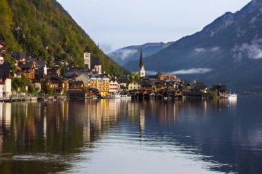 Hallstatt, Avusturya - 24 Şubat 2015: Güzel dağ şehri Hallstatt bir sonbahar sabahı görüldüğü gibi göldeki binaların yansımasıyla.