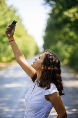 Profile pose of a woman searching the phone service.