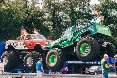 FRANKFURT, GERMANY -AUGUST 24, 2015 : People admiring two colored Monster Trucks exposed at a presentation in Frankfurt .