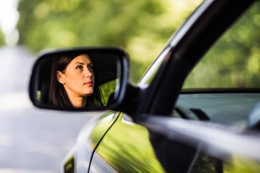 Odaklanırken kadın sürücünün aynadaki görüntüsü.