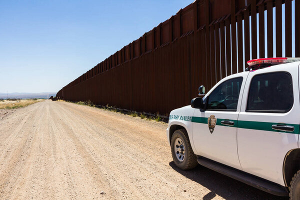 Arizona, USA - June 28, 2016: Police car stopped near the border fence of the USA .
