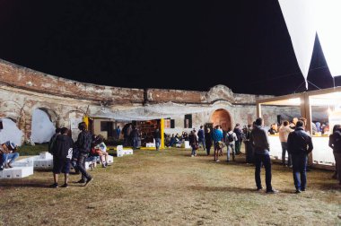 İnsanlar yürüyor, dinleniyor ve konserin başlamasını bekliyor.