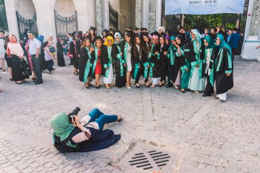 Fotoğrafçı, İstanbul, Türkiye 'deki mezuniyetlerinde kameraya gülümseyen bir grup genç Türk kadını poz verirken yere uzandı.