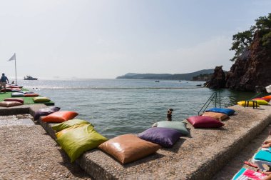 Büyükada, Türkiye - 28 Haziran 2014: Türkiye 'de bir plajda deniz kenarındaki bir rıhtımda renkli yastıkların kapatılması