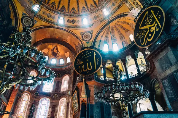 İstanbul, Türkiye - 26 Haziran 2014: Güzel avizenin pozu ve Ayasofya Camii 'nin geleneksel duvarlarını boyadı