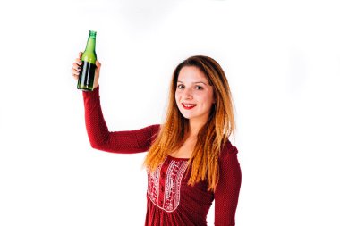Genç ve gülümseyen bir kadının Noel 'i kutlaması ve beyaz bira şişesiyle tezahürat yapması..