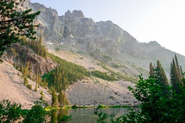 Orta Oregon 'daki Çilek Dağı' nda Küçük Çilek Gölü 'nün üzerinde büyük kayalıklar ve kayalıklar var..