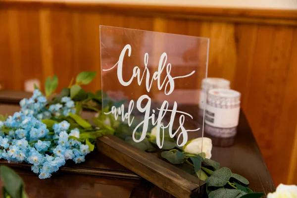 Clear wedding sign with white letters at a wedding reception labeled cards and gifts.