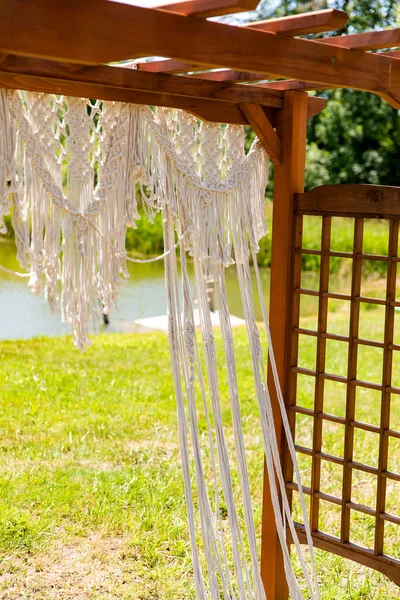 Outdoor wedding pergola arbor decorated with lace before a ceremony.