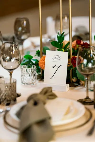 Wedding reception table numbers with table seven at an indoor celebration.