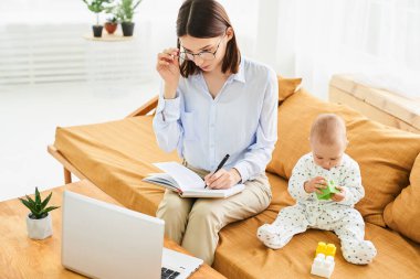 Genç, mutlu anne ve oğlu bilgisayarda bir şeyler arıyorlar. Dizüstü bilgisayarda çalışan bir kadın, kanepe başında annesiyle oturan bir çocuk, aile kavramı..