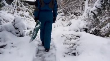 Mutlu genç kadın evin yakınındaki bahçede kar temizliyor. Elinde kar küreği olan bir kızın portresi. Mutlu kız bahçedeki evin yakınındaki karı kaldırıyor. Mutluluk kavramı, neşe. 