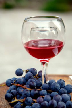 Kırmızı şarap ve bir demet üzümlü bardaklar. Bardakta kırmızı şarap ve bir demet üzümlü kompozisyon. yan görünüm, üst görünüm. 