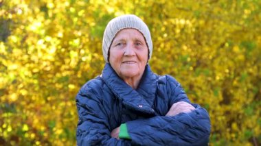 Parkta yürüyen yaşlı bir kadının portresi. Ormandaki temiz havada kırışıklıklar olan yaşlı bir kadının yüzü..