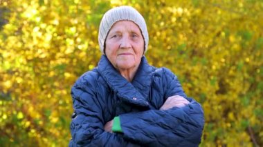 Parkta yürüyen yaşlı bir kadının portresi. Ormandaki temiz havada kırışıklıklar olan yaşlı bir kadının yüzü..