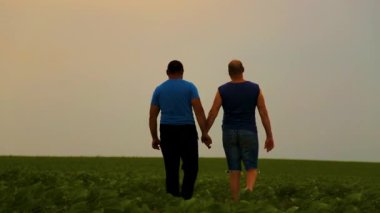 Doğada yürüyen iki yakışıklı eşcinselin duygusal kucaklaşması. Evin dışında yürüyüş yapan mutlu eşcinsel çift, eğleniyorlar. Mutluluk kavramı, ilişkiler, LGBT. 