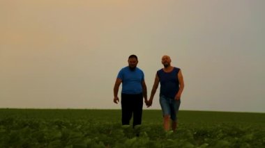 Doğada yürüyen iki yakışıklı eşcinselin duygusal kucaklaşması. Evin dışında yürüyüş yapan mutlu eşcinsel çift, eğleniyorlar. Mutluluk kavramı, ilişkiler, LGBT. 