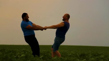 Doğada yürüyen iki yakışıklı eşcinselin duygusal kucaklaşması. Evin dışında yürüyüş yapan mutlu eşcinsel çift, eğleniyorlar. Mutluluk kavramı, ilişkiler, LGBT. 