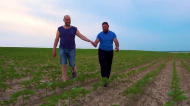 Doğada yürüyen iki yakışıklı eşcinselin duygusal kucaklaşması. Evin dışında yürüyüş yapan mutlu eşcinsel çift, eğleniyorlar. Mutluluk kavramı, ilişkiler, LGBT. 