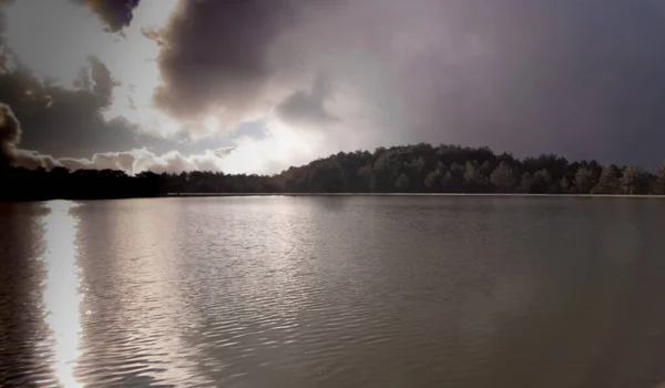 Scenic view of lake under cloudy sky 