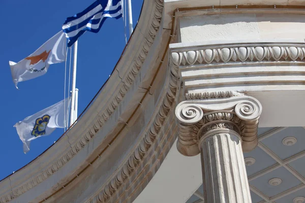 partial view of ancient architecture arch with flags, blue sky on background 