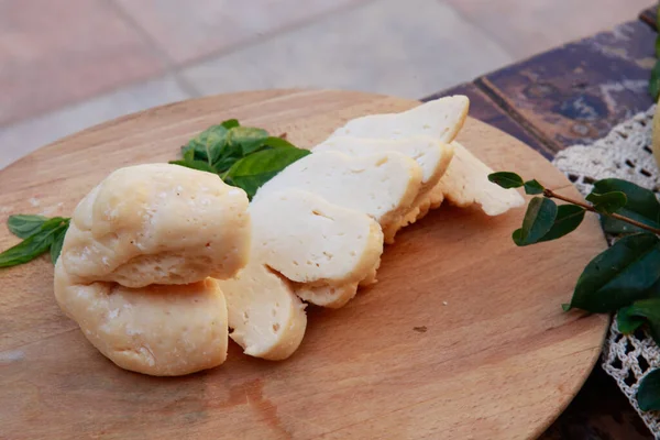 Kesme tahtasındaki dilimlenmiş bir parça halloumi. Kıbrıs geleneksel yemekleri