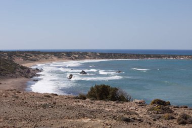 Paphos, Kıbrıs Rum Kesimi 'nden Akamas Yarımadası, deniz kıyılarının havadan görünüşü, vahşi plaj, sarı manzara, mavi lagün, popüler turizm merkezi.