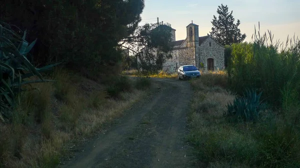 車の道路上で 背景に古代ギリシャの修道院と駐車 — ストック写真