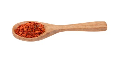 Beyaz arka planda tahta kaşıkta kırmızı biber yığını