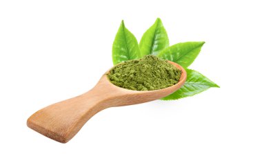 Tahta kaşıkta kibrit yeşil çay tozu ve beyaz arka planda yapraklar.