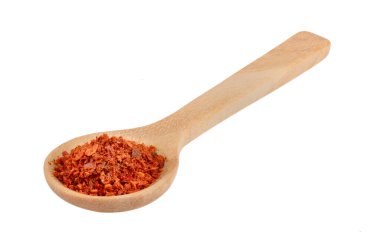 Beyaz arka planda tahta kaşıkta kırmızı biber yığını