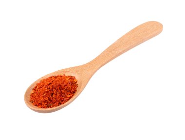 Beyaz arka planda tahta kaşıkta kırmızı biber yığını