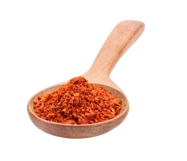 Beyaz arka planda tahta kaşıkta kırmızı biber yığını