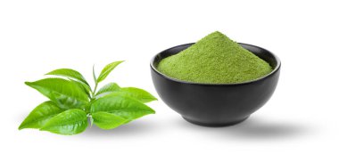 Beyaz arka planda yaprakları olan bir kasede kibrit yeşil çay tozu.