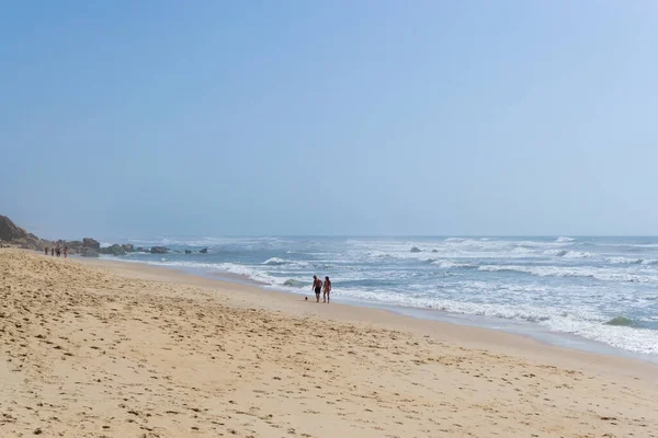 Okyanus kıyısında insanların dinlendiği bir sahil, tatil yeri. Dağlar, deniz ve dalgalar. Avrupa 'ya, Portekiz' e git. Praia de Vale Furado.